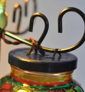Upcycle old glass jars into a lamp. Seen here: punch holes into the bottle cap for ventilation and stringing up